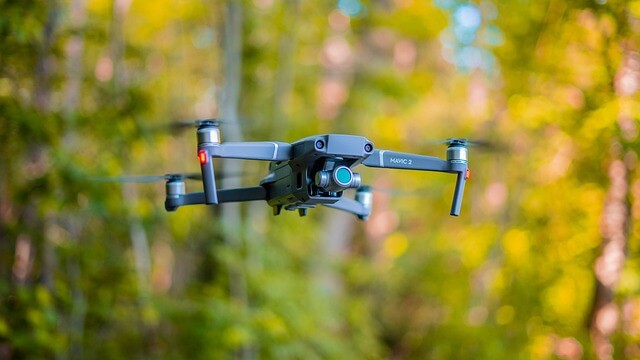 Hovering DJI Mavic 2 Pro drone with trees in the background from drone services Bristol